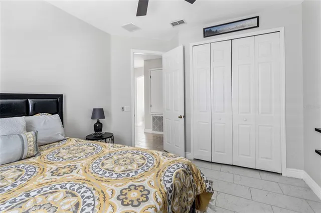 a bedroom with a bed a couch and a flat screen tv