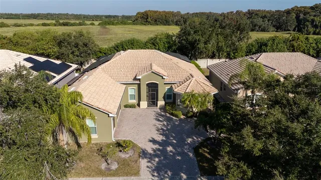 an aerial view of a house with backyard and fountain