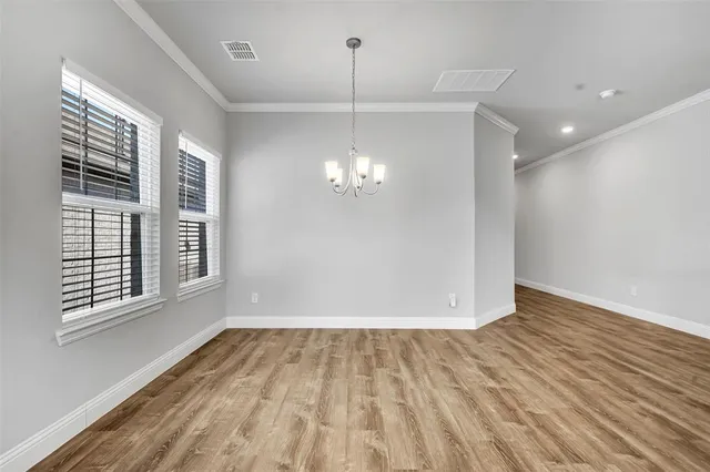 a view of a room with wooden floor and chandelier