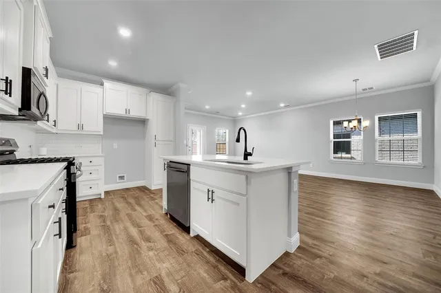 a kitchen with a sink stainless steel appliances and cabinets