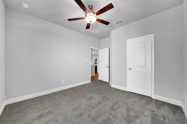 an empty room with closet and fan
