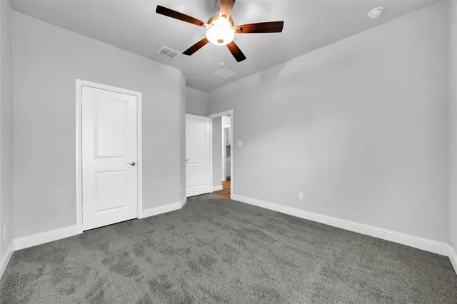 an empty room with chandelier fan