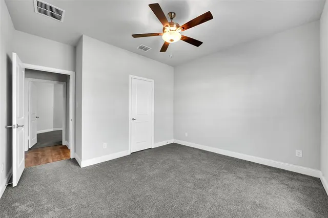 an empty room with closet and fan
