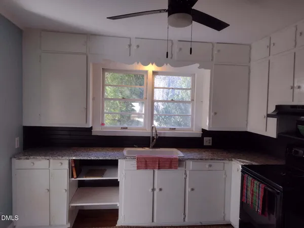 a dining room with furniture a chandelier and window