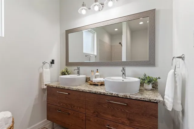a bathroom with a granite countertop sink and a mirror