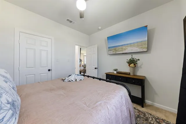 a bedroom with a bed and a painting on the wall