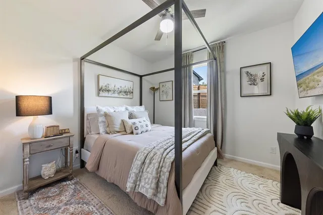 a bedroom with a large bed and a flat tv screen on the dresser