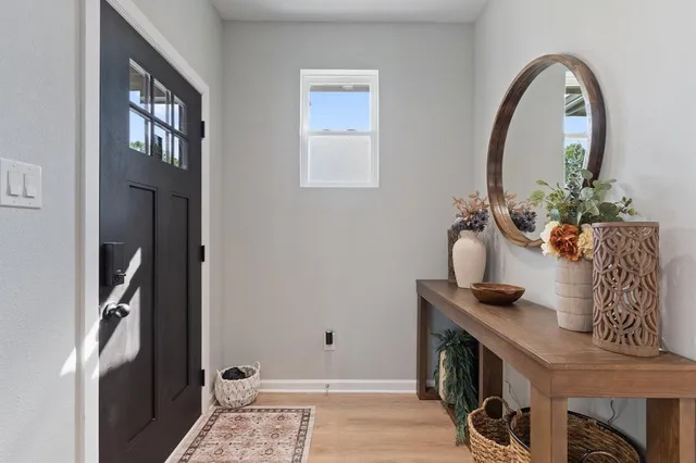 a view of hall way with furniture and mirror in it