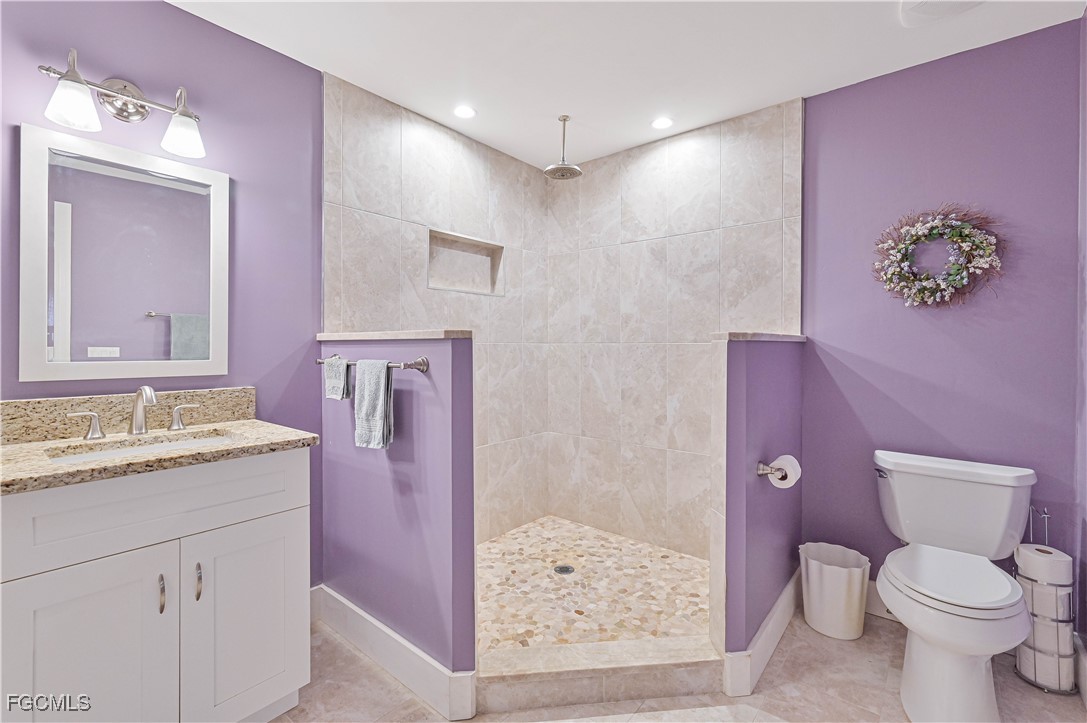 18217 Sycamore Road Fort Myers, FL 33967 - Photo 21 of 35 a bathroom with a granite countertop sink a toilet a mirror and shower
