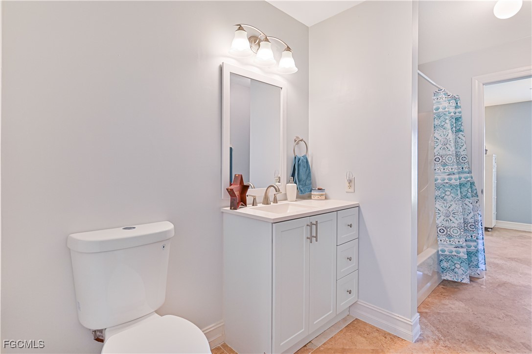 18217 Sycamore Road Fort Myers, FL 33967 - Photo 26 of 35 a bathroom with a toilet a sink and mirror