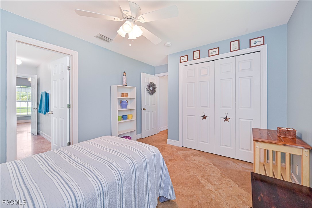 18217 Sycamore Road Fort Myers, FL 33967 - Photo 27 of 35 a bedroom with a large bed and a chandelier
