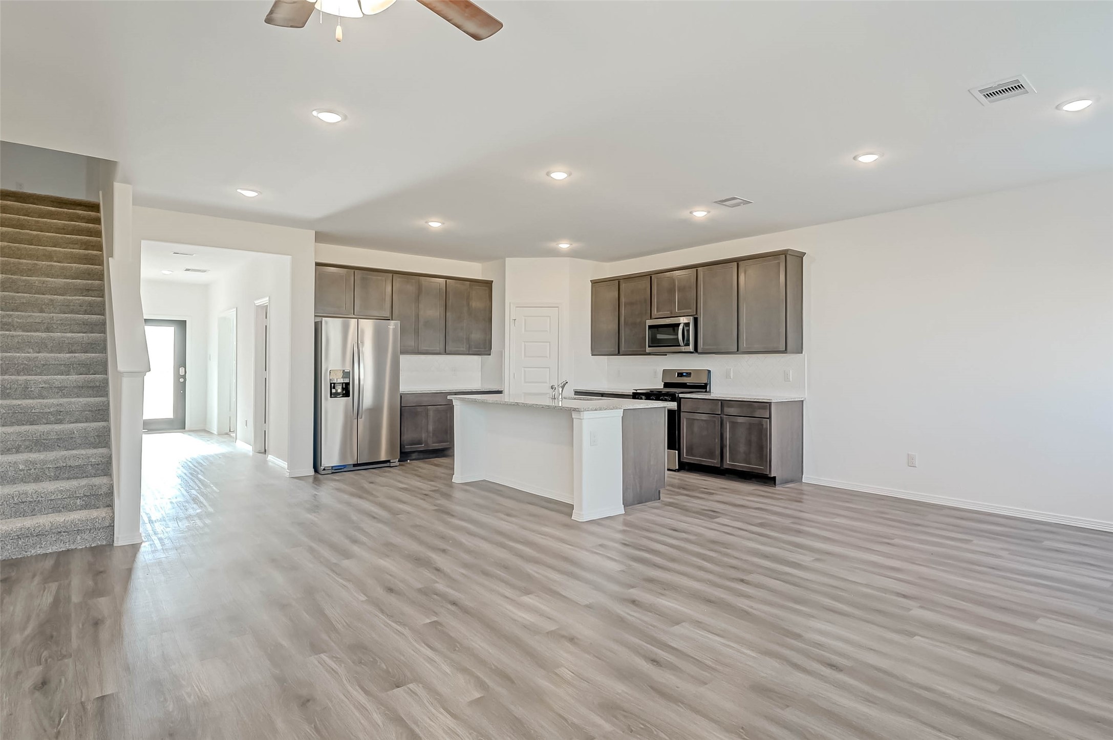 a large kitchen with stainless steel appliances granite countertop a large counter top and a sink