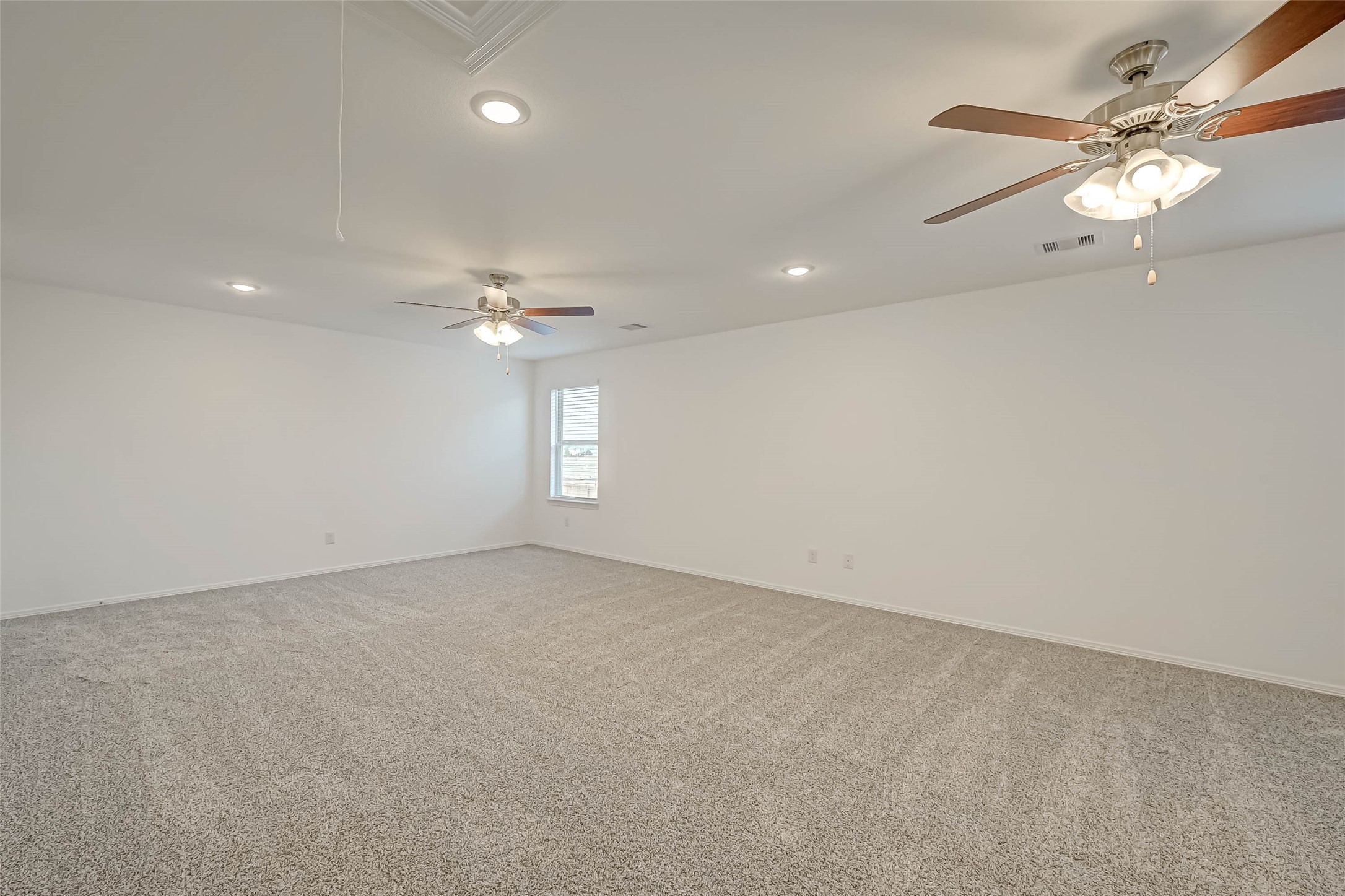 23226 Morning Splendor Drive Katy, TX 77493 - Photo 19 of 22 an empty room with a chandelier fan and windows