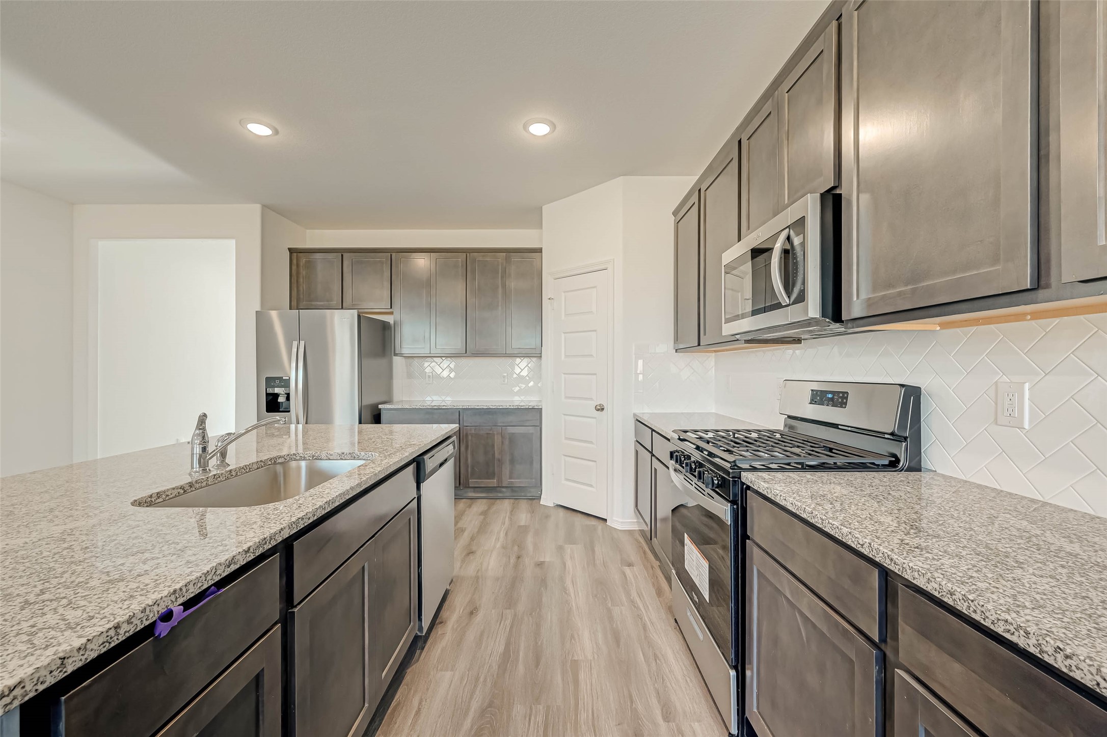 23226 Morning Splendor Drive Katy, TX 77493 - Photo 7 of 22 a kitchen with granite countertop stainless steel appliances a sink stove top oven and cabinets