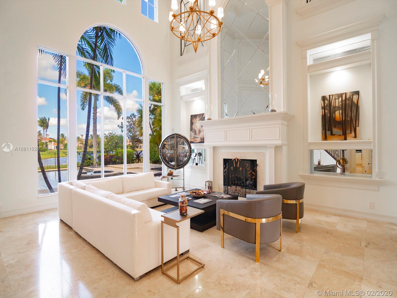 a living room with furniture a fireplace and a chandelier