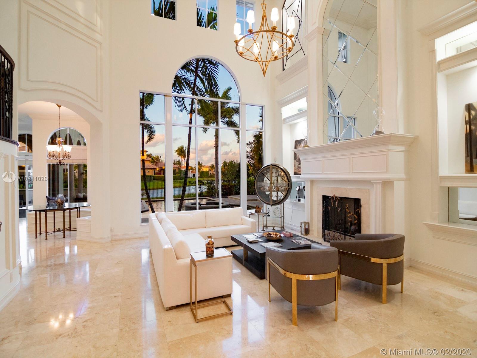 9597 Bridgebrook Drive Boca Raton, FL 33496 - Photo 2 of 37 a living room with furniture a fireplace and a chandelier