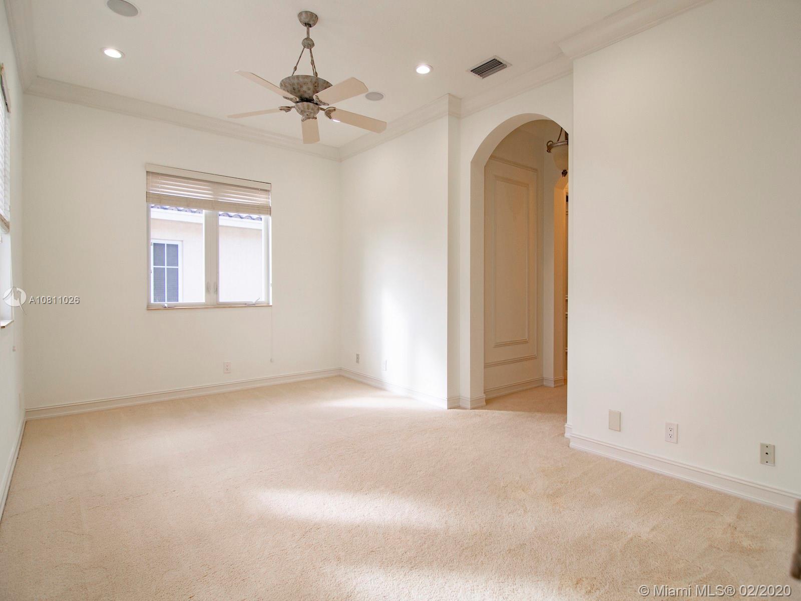 9597 Bridgebrook Drive Boca Raton, FL 33496 - Photo 24 of 37 an empty room with a chandelier fan and windows