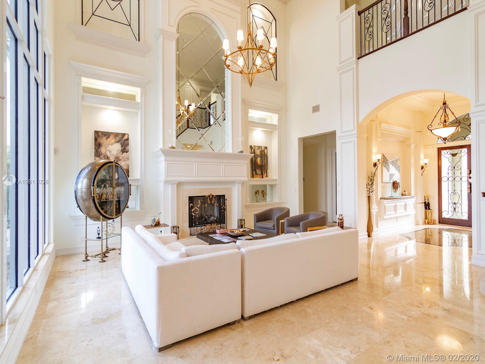 9597 Bridgebrook Drive Boca Raton, FL 33496 - Photo 27 of 37 a living room with furniture a fireplace and a chandelier