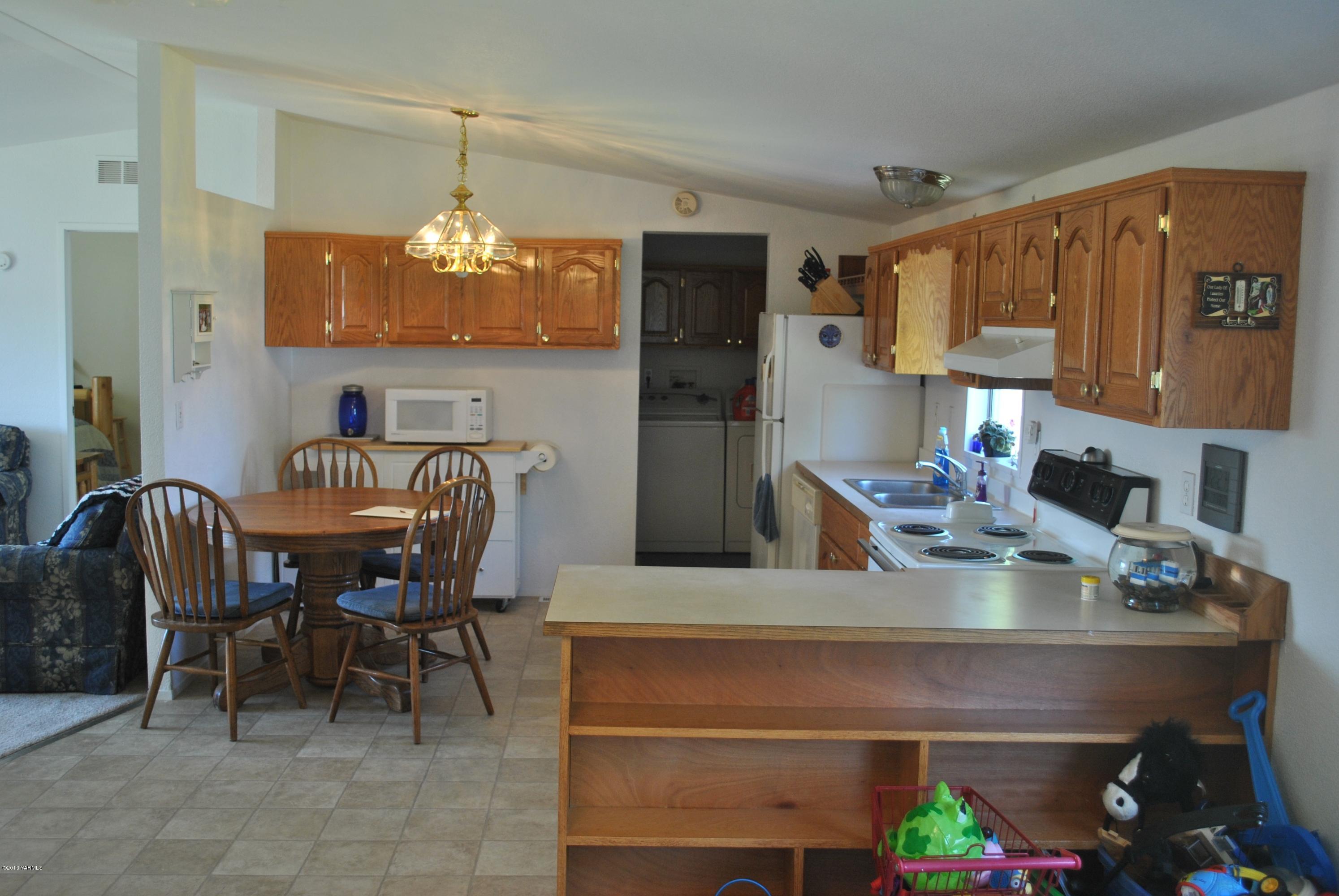 1231 Holaday Road Mabton, WA 98935 - Photo 2 of 29 a kitchen with a dining table chairs and chandelier