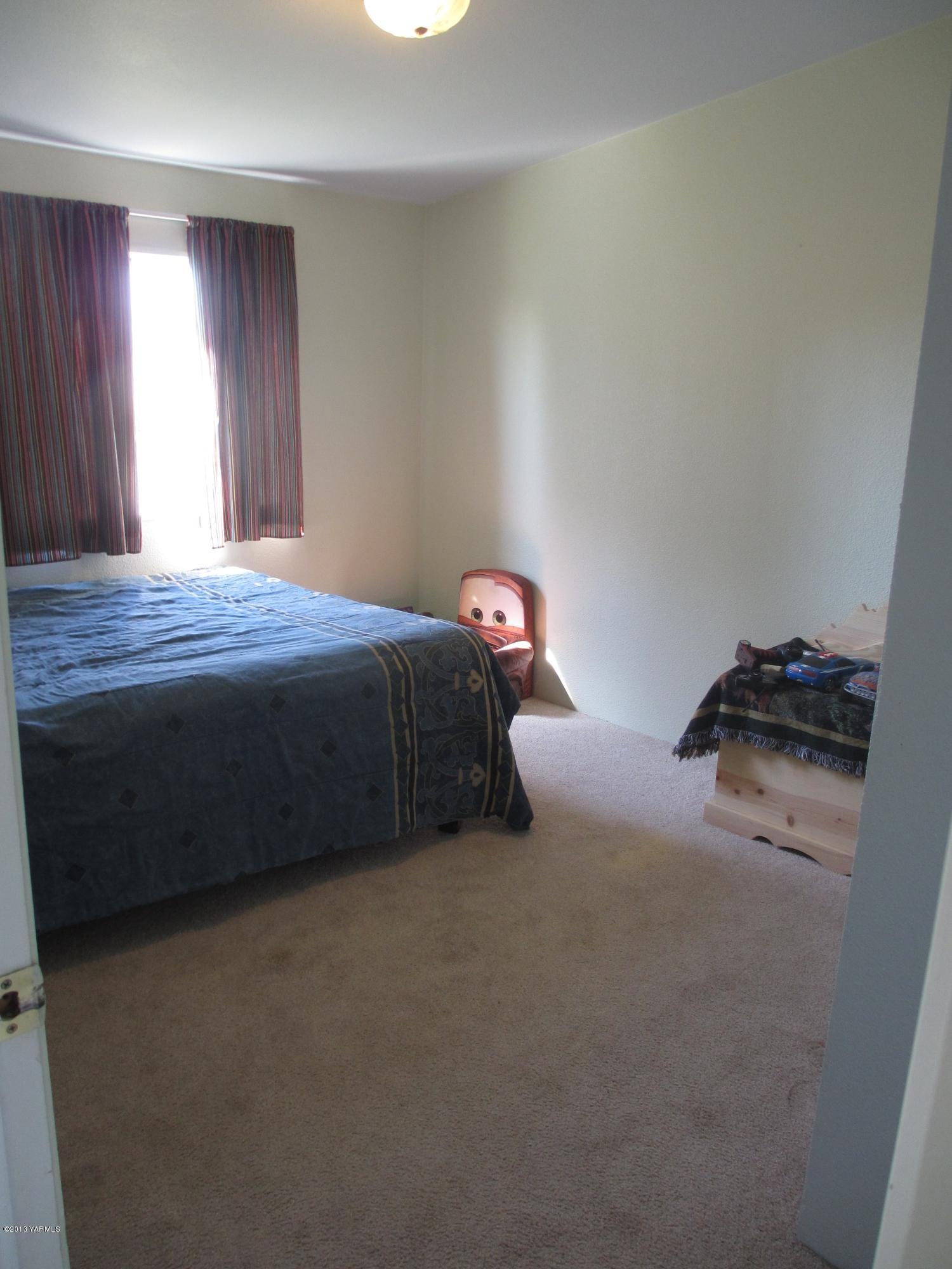 1231 Holaday Road Mabton, WA 98935 - Photo 13 of 29 a bedroom with a bed and a window
