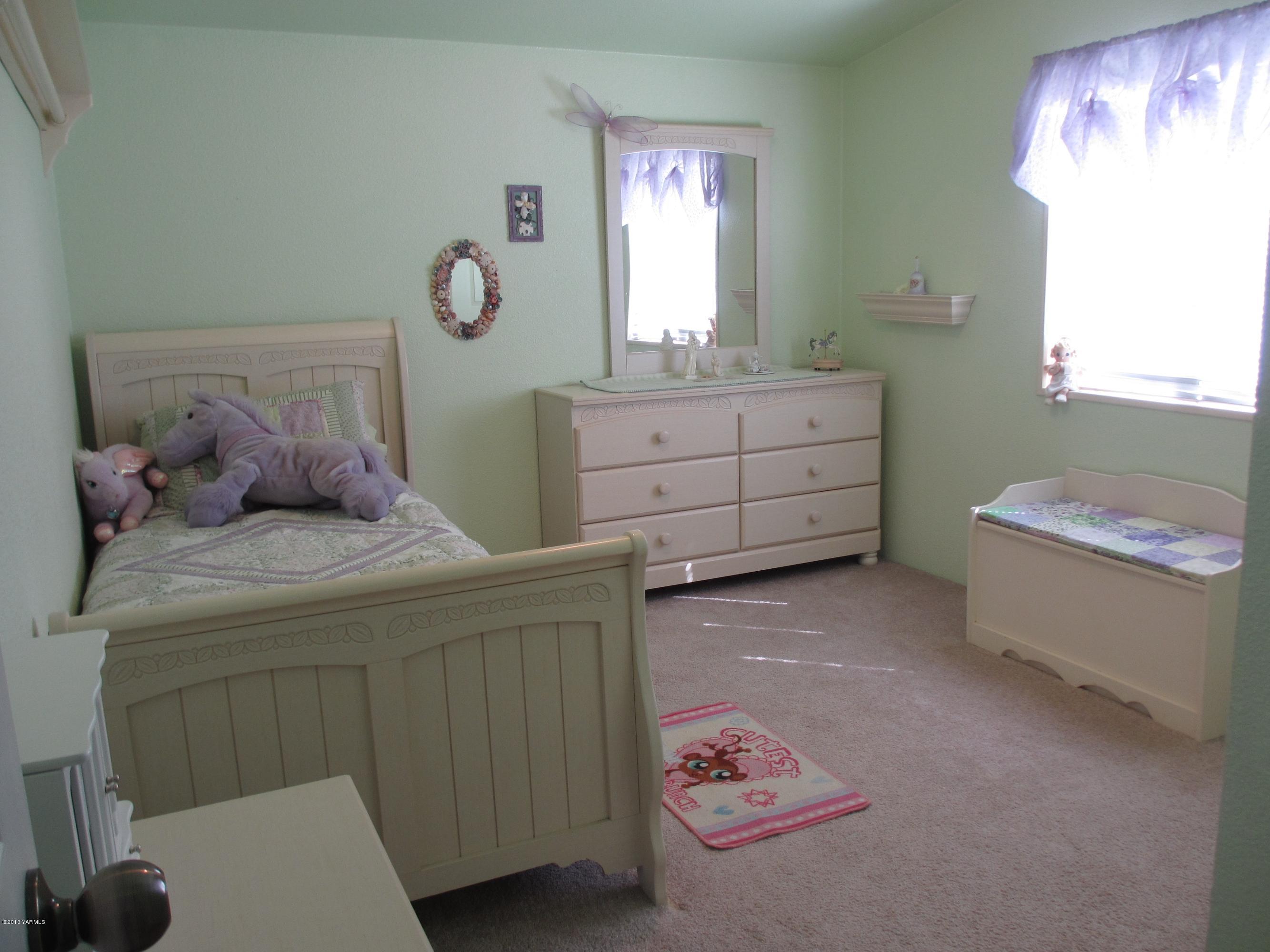 1231 Holaday Road Mabton, WA 98935 - Photo 14 of 29 a bedroom with a bed and a chandelier