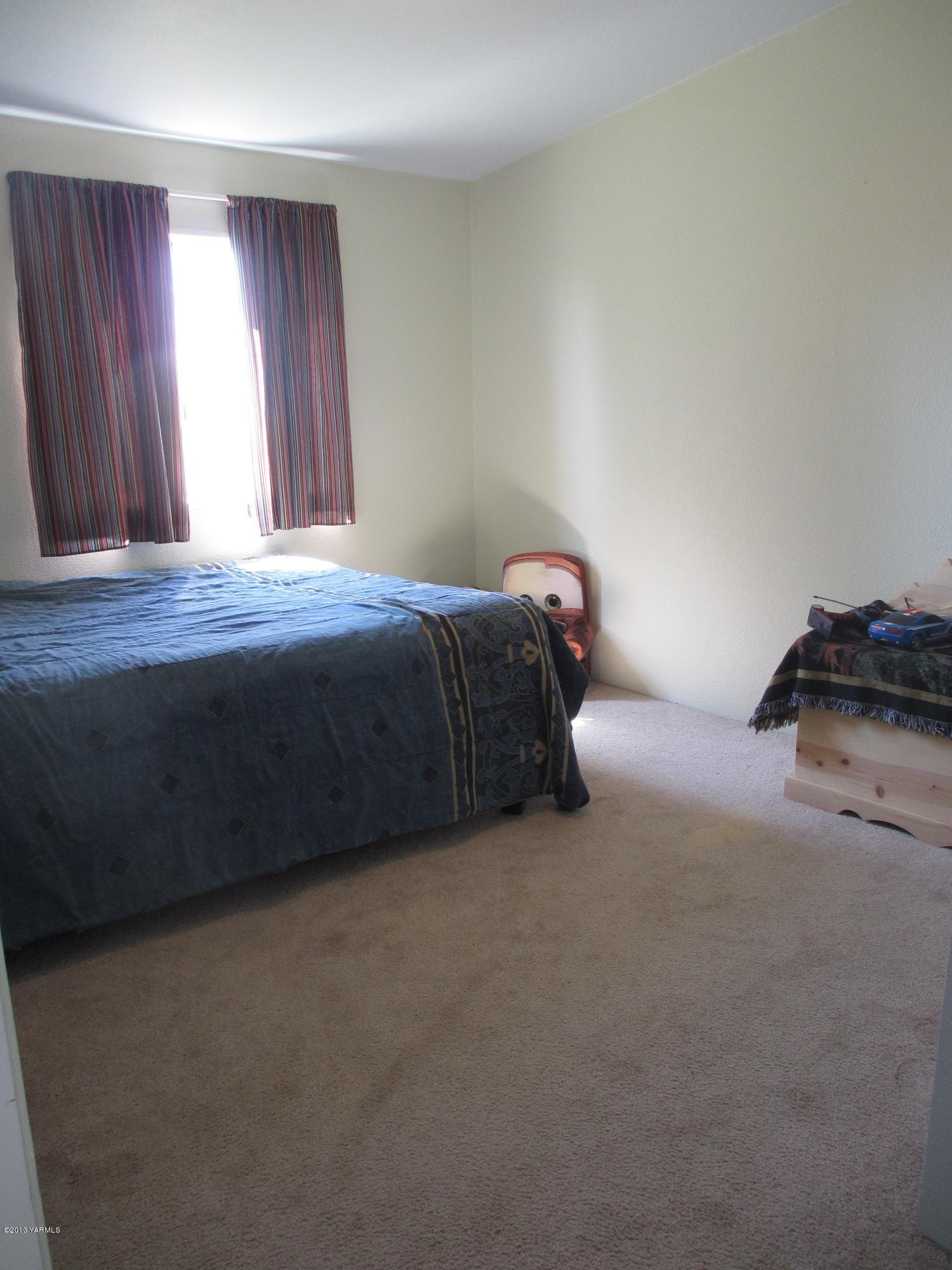1231 Holaday Road Mabton, WA 98935 - Photo 9 of 29 a bed sitting in a bedroom next to a window