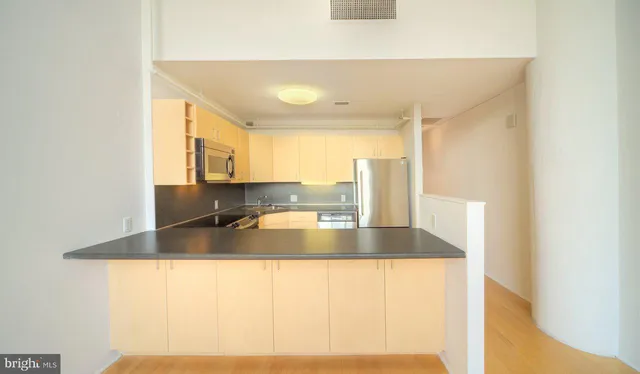 a view of a kitchen with kitchen island a sink and a large window
