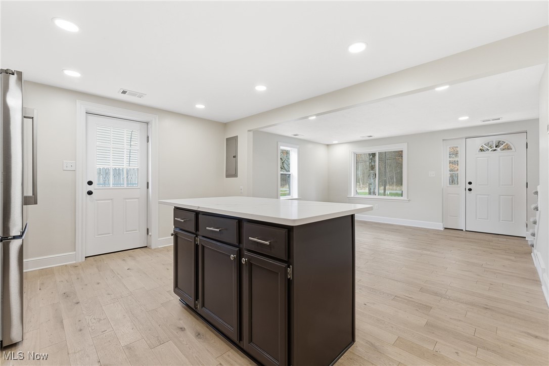 3793 Ranfield Road Kent, OH 44240 - Photo 37 of 40 Kitchen with light wood-style flooring, a kitchen island, recessed lighting, open floor plan, and freestanding refrigerator