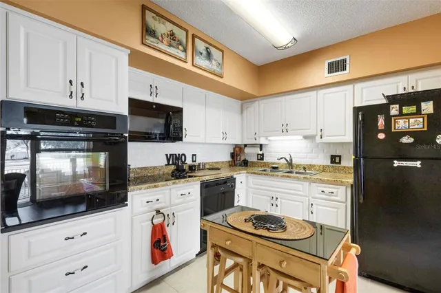 a kitchen with stainless steel appliances granite countertop a stove top oven a sink a counter space and cabinets