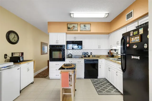 a kitchen with granite countertop white cabinets and white appliances
