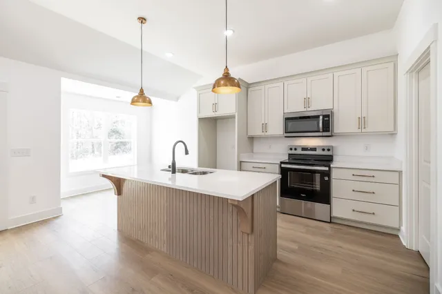 a kitchen with kitchen island a sink stainless steel appliances and cabinets