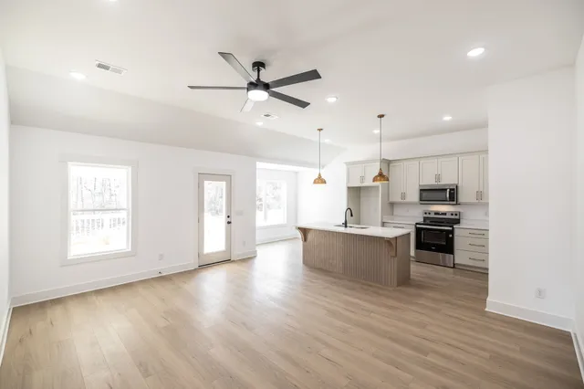 a large kitchen with a lot of counter space and wooden floor