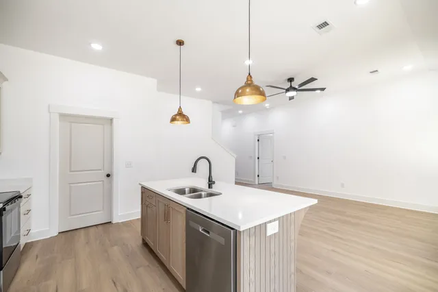 a kitchen with a sink and wooden floor