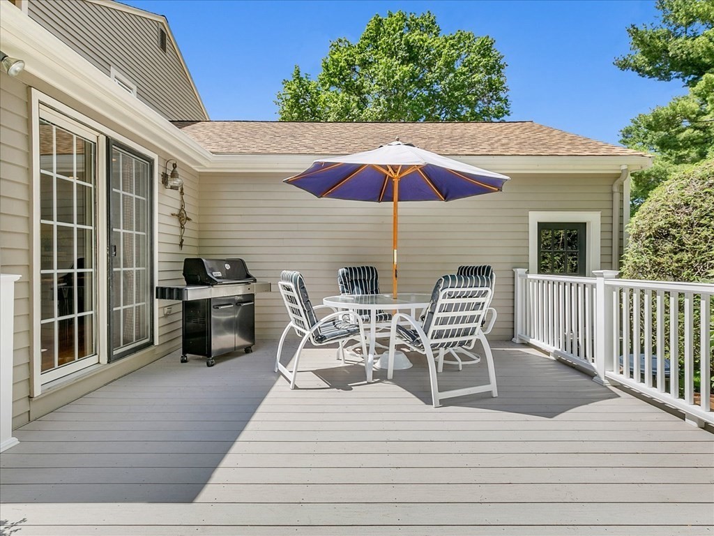 108 Meadowbrook Road Needham, MA 02492 - Photo 8 of 38 a view of a roof deck with table and chairs under an umbrella with wooden floor