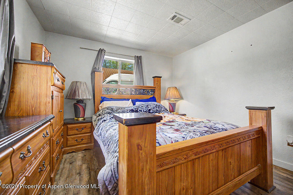 625 Russell Street Craig, CO 81625 - Photo 27 of 35 a bedroom with bed and wooden floor
