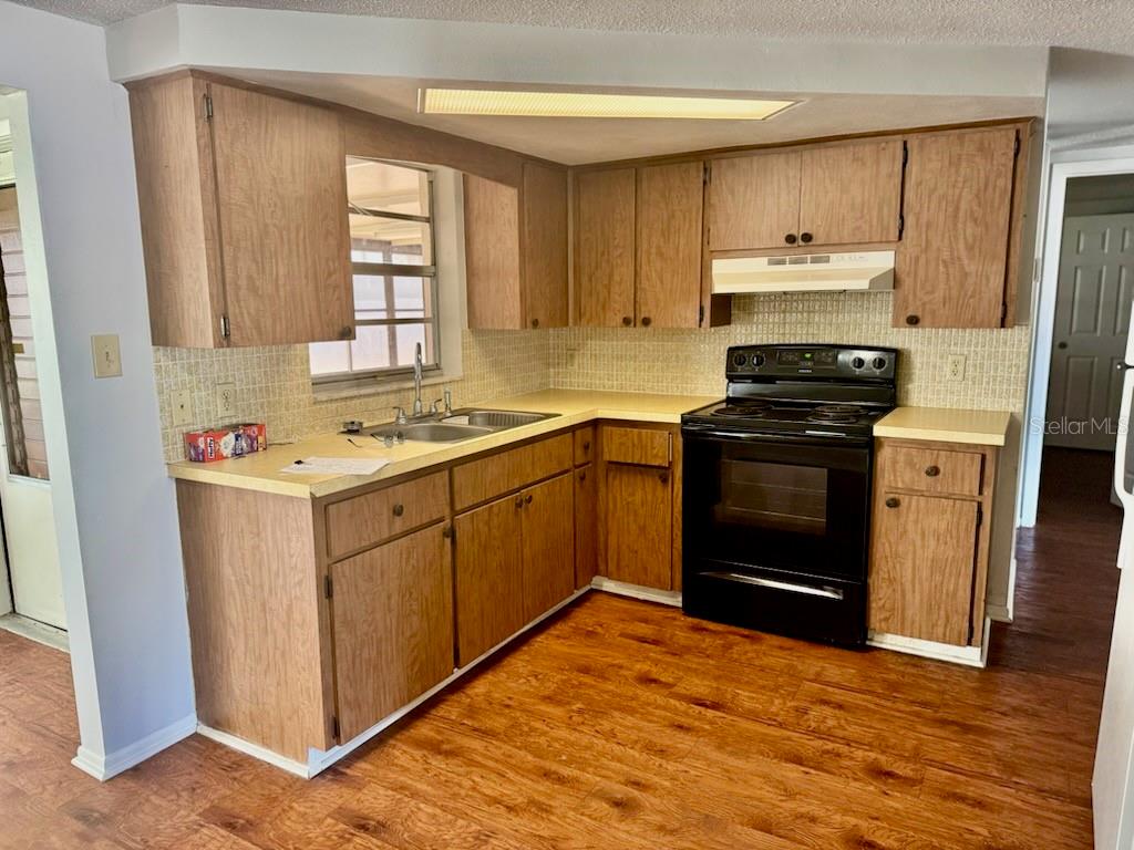 9617 Lake Chrise Lane Port Richey, FL 34668 - Photo 2 of 6 a kitchen with stainless steel appliances a stove sink and cabinets