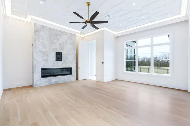 an empty room with ceiling fan and windows