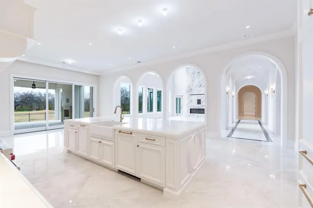 a large white kitchen with a large window