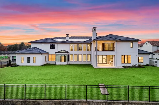 a view of a house with a big yard and large trees
