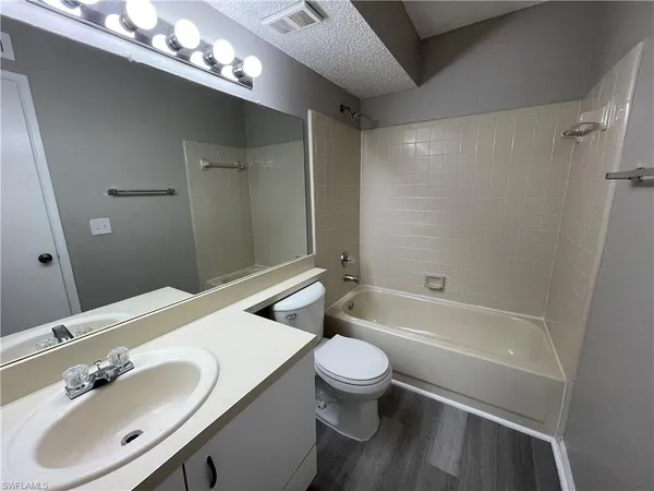 a bathroom with a sink vanity granite toilet tub and shower