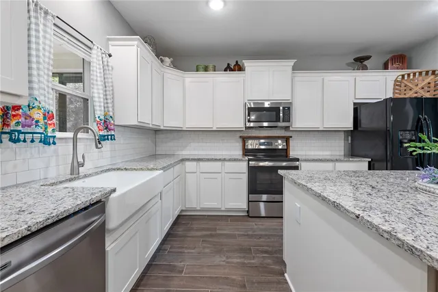 a kitchen with granite countertop a sink stove and cabinets
