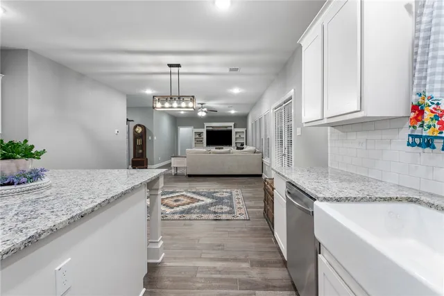 a large kitchen with kitchen island granite countertop a sink stainless steel appliances and cabinets