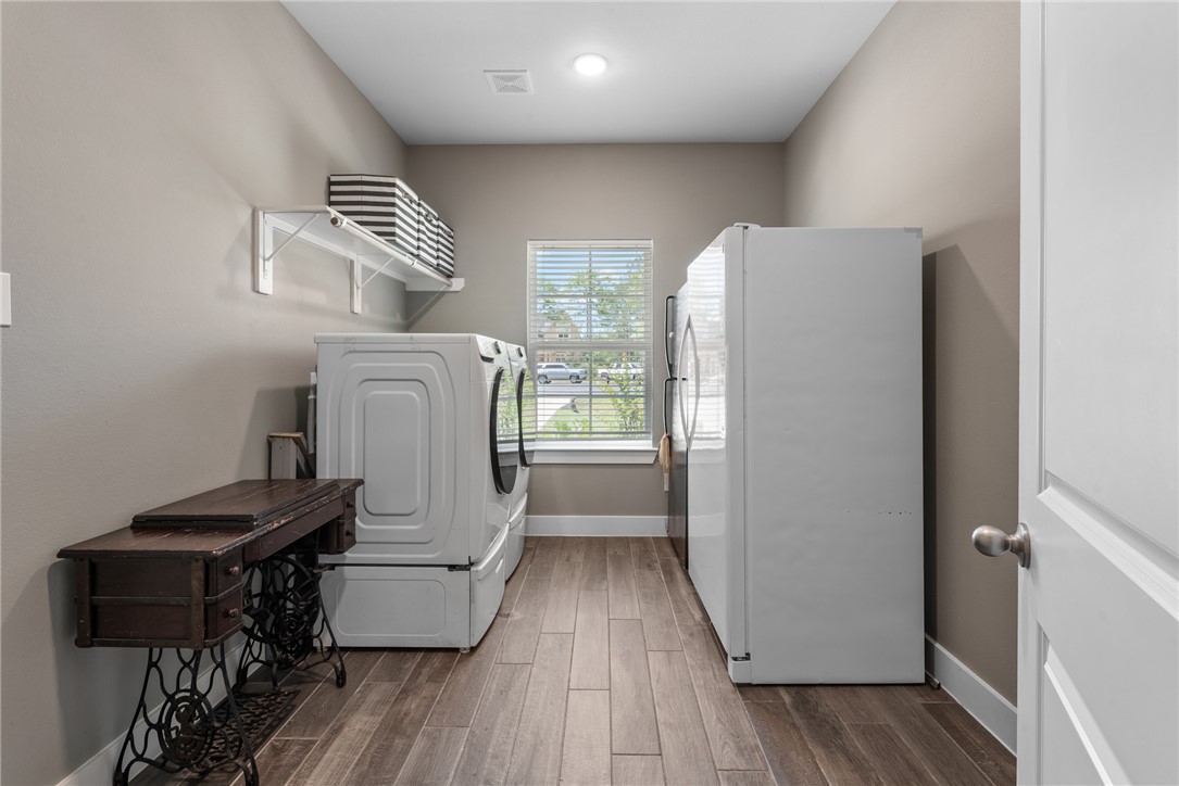 8729 Nathan Drive Waller, TX 77484 - Photo 18 of 48 Laundry area featuring washer / clothes dryer and wood finished floors