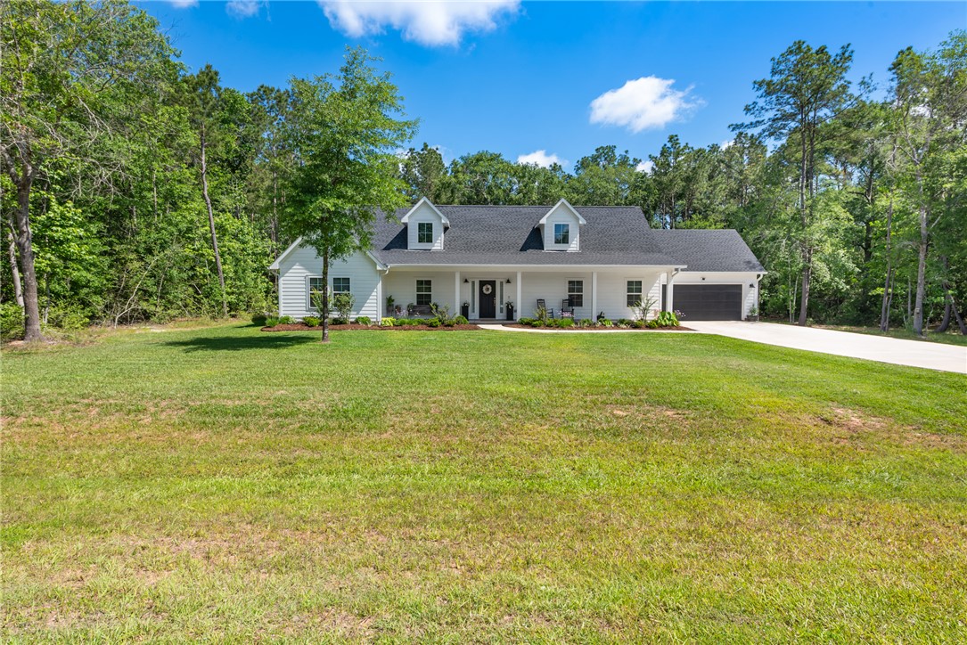 8729 Nathan Drive Waller, TX 77484 - Photo 2 of 48 View of front facade with covered porch, a garage, driveway, and a front lawn