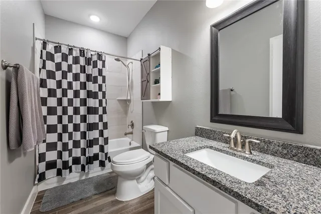 a bathroom with a granite countertop sink toilet and shower