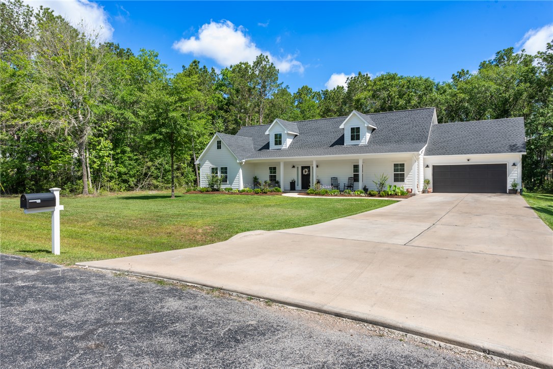 8729 Nathan Drive Waller, TX 77484 - Photo 3 of 48 Cape cod house featuring a front yard, a garage, concrete driveway, and a shingled roof