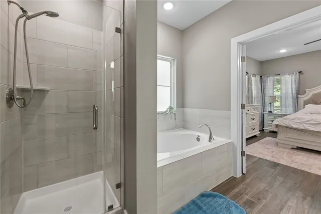 a bathroom with a tub a sink and a shower