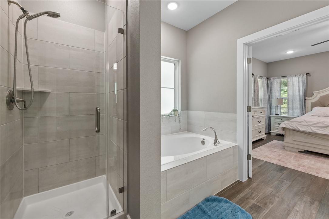8729 Nathan Drive Waller, TX 77484 - Photo 33 of 48 Ensuite bathroom featuring a shower stall, a garden tub, and wood finished floors