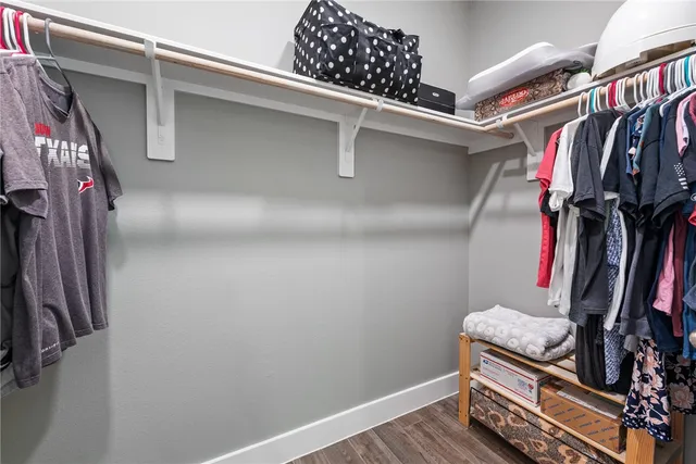 a view of walk in closet with clothes