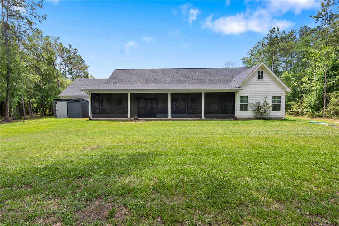 8729 Nathan Drive Waller, TX 77484 - Photo 40 of 48 Rear view of house featuring a sunroom, roof with shingles, and a yard